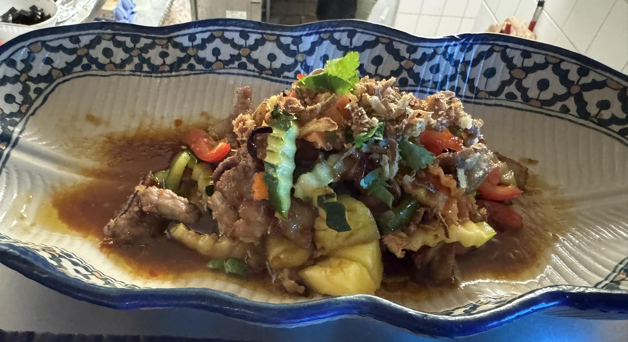 plat typique thaïlandais coloré par Nock Thai à Limoux avec viande, ananas, légumes frais et herbes dans un plat décoré,